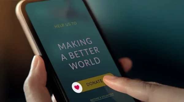 Hand using a phone to make an online donation to support a nonprofit