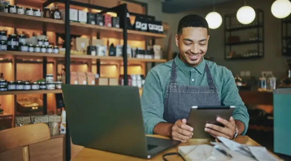 Small business owner in Chicago smiling while reviewing updates to his website on a computer