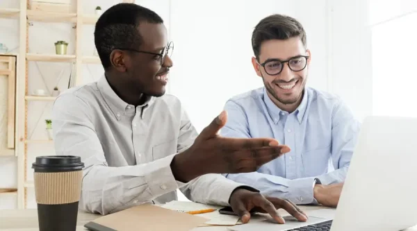 Two business professionals reviewing a web design project on a laptop in a Chicago office